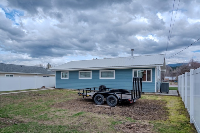 308 Dakota Ave, Libby, MT 59923 - back of property featuring metal roof, cooling unit, a yard, and fence private yard
