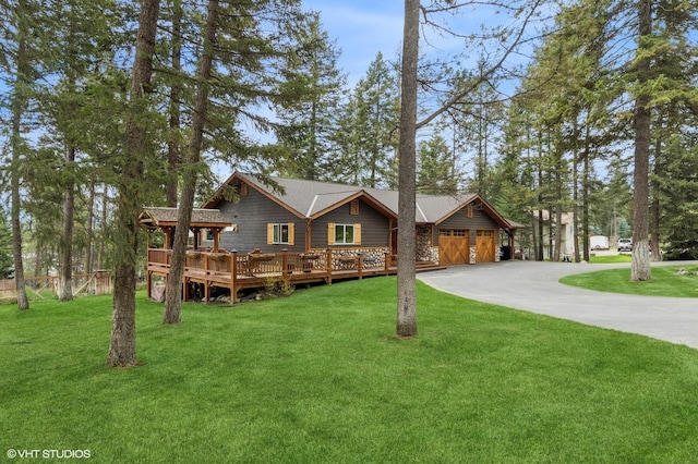 view of front of home with driveway, a front yard, and a wooden deck