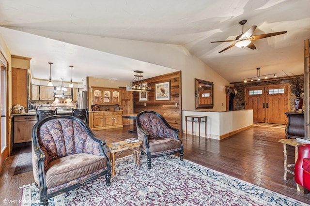 living room with hardwood / wood-style floors, ceiling fan, vaulted ceiling, and baseboards