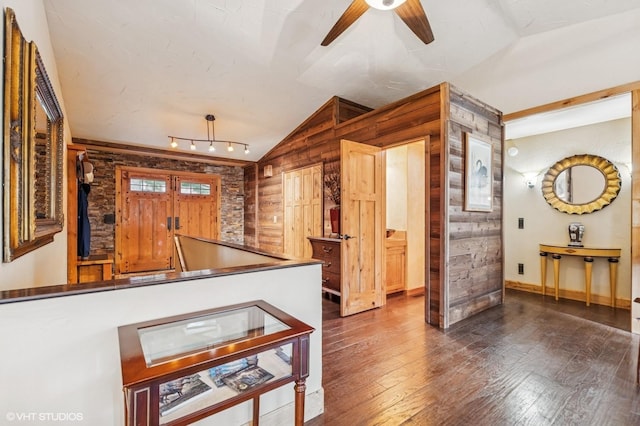 interior space with vaulted ceiling, a ceiling fan, wood-type flooring, and baseboards