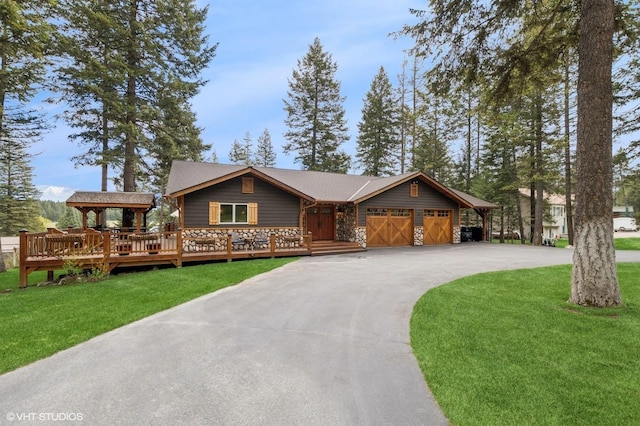 rustic home featuring an attached garage, a front lawn, driveway, and stone siding