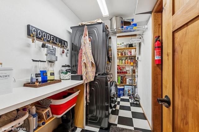 washroom featuring stacked washer and clothes dryer and tile patterned floors