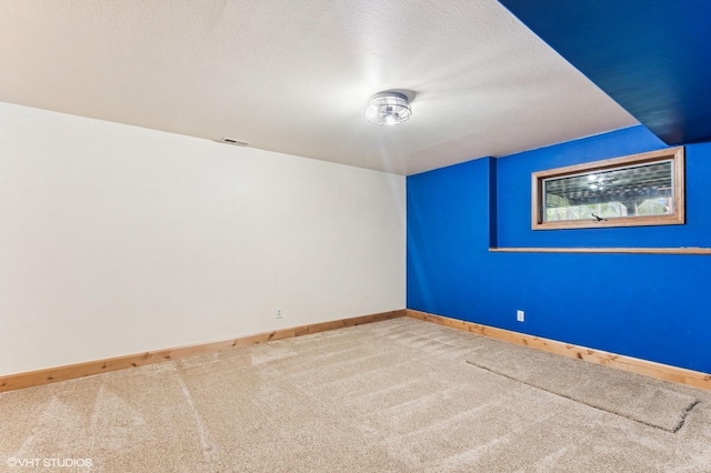 spare room with baseboards and light carpet