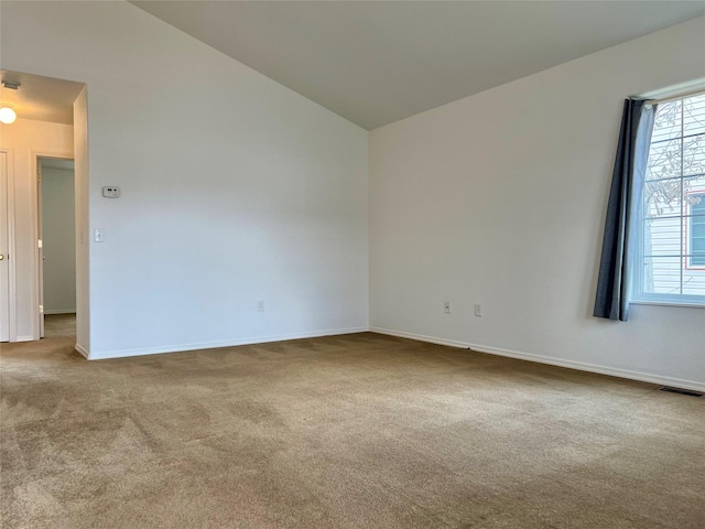 empty room with baseboards, carpet, lofted ceiling, and visible vents