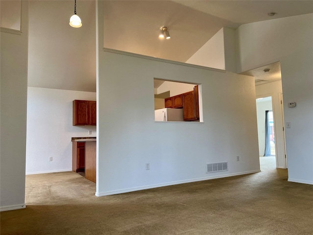 unfurnished living room featuring carpet floors, high vaulted ceiling, baseboards, and visible vents