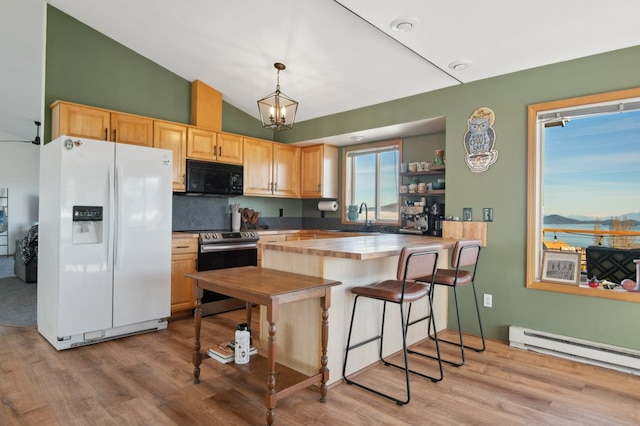 18 Mission View Dr, Polson, MT 59860 - kitchen with white fridge with ice dispenser, black microwave, electric range, light wood finished floors, and high vaulted ceiling