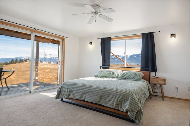 18 Mission View Dr, Polson, MT 59860 - bedroom featuring access to exterior, a mountain view, light colored carpet, baseboards, and a ceiling fan