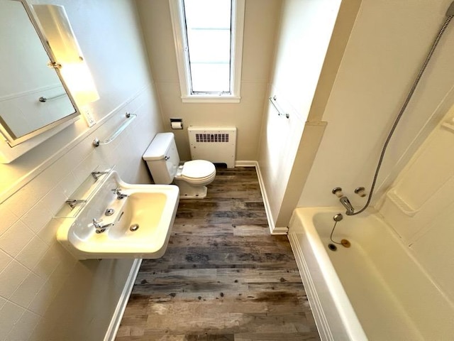 659-665 Logan St, Helena, MT 59601 - full bath featuring radiator, toilet, a washtub, walk in shower, and wood finished floors
