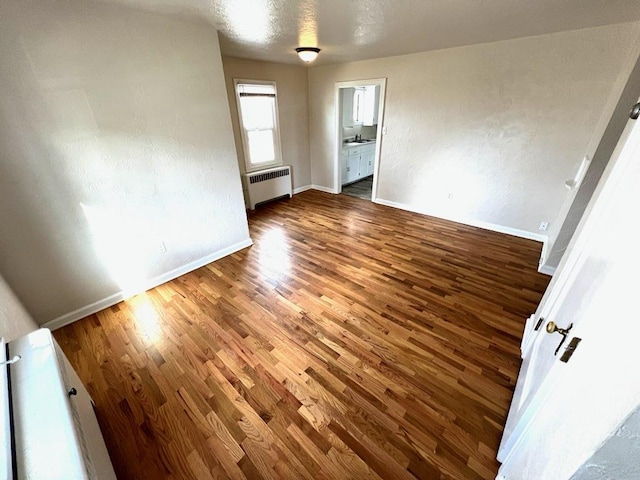 659-665 Logan St, Helena, MT 59601 - empty room with baseboards, wood finished floors, and radiator heating unit