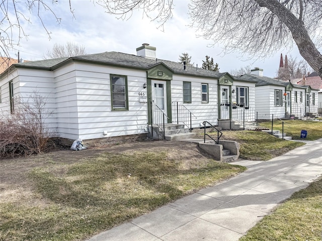 659-665 Logan St, Helena, MT 59601 - view of front of house featuring a chimney, a front yard, and entry steps