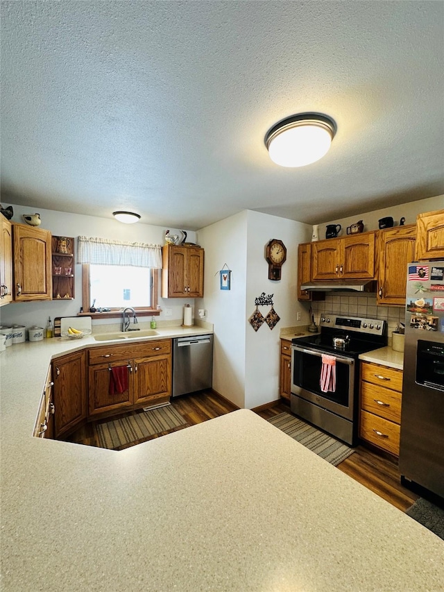 47 3rd Ave S, Stanford, MT 59479 - kitchen featuring stainless steel appliances, a sink, a textured ceiling, under cabinet range hood, and dark wood-type flooring