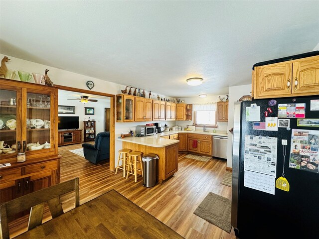 47 3rd Ave S, Stanford, MT 59479 - kitchen featuring appliances with stainless steel finishes, a peninsula, light wood-type flooring, and a kitchen breakfast bar
