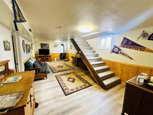47 3rd Ave S, Stanford, MT 59479 - living area featuring stairs, wood walls, wood finished floors, wainscoting, and a textured ceiling