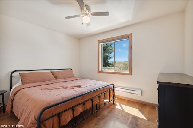 155 Spring Ln, Eureka, MT 59917 - bedroom with baseboards, ceiling fan, wood finished floors, and baseboard heating