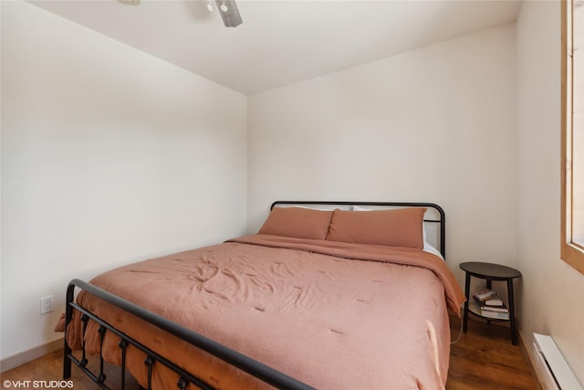 155 Spring Ln, Eureka, MT 59917 - bedroom with baseboards, baseboard heating, wood finished floors, and a ceiling fan