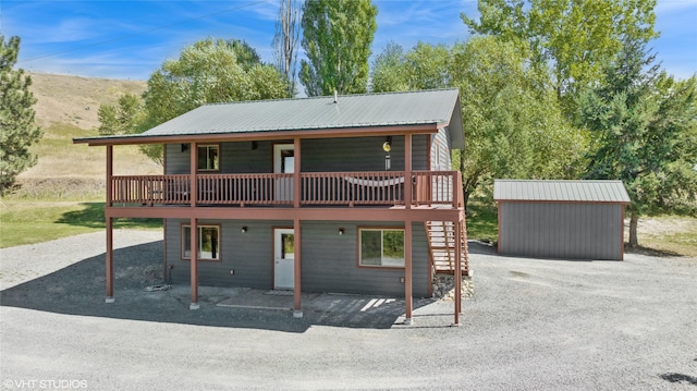 155 Spring Ln, Eureka, MT 59917 - chalet / cabin featuring stairs, metal roof, gravel driveway, and a wooden deck