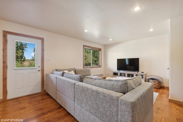 155 Spring Ln, Eureka, MT 59917 - living area with light wood finished floors, a textured ceiling, baseboards, a baseboard heating unit, and recessed lighting