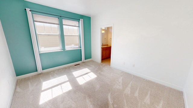 unfurnished room with baseboards, visible vents, and carpet