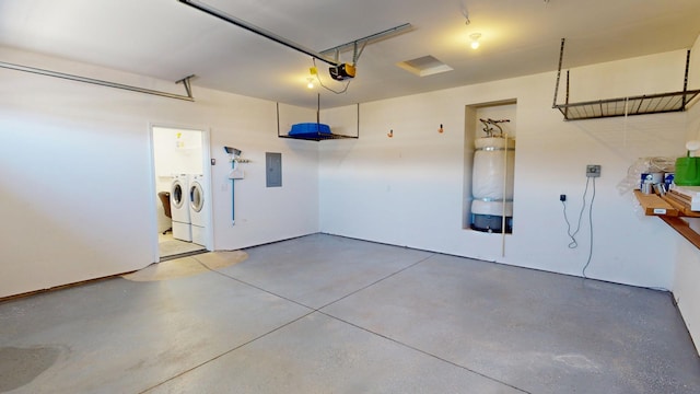 garage featuring a garage door opener, separate washer and dryer, and electric panel