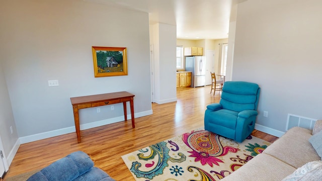 sitting room featuring light wood finished floors, baseboards, and visible vents