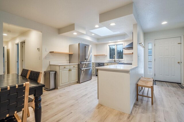 kitchen with a peninsula, open shelves, appliances with stainless steel finishes, a sink, and light wood finished floors