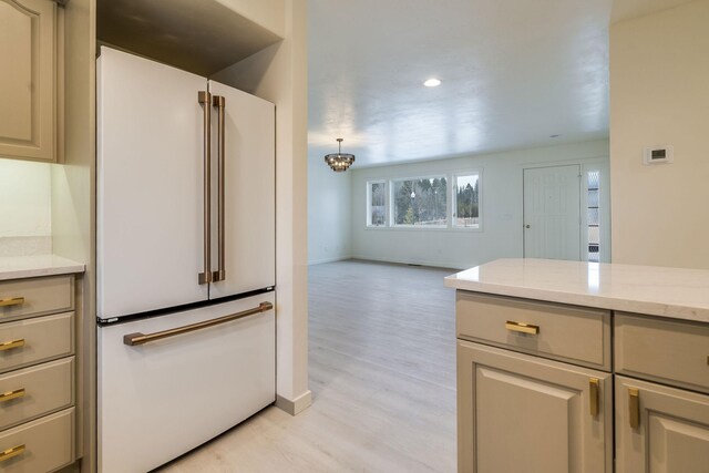kitchen featuring light wood finished floors, open floor plan, freestanding refrigerator, and baseboards