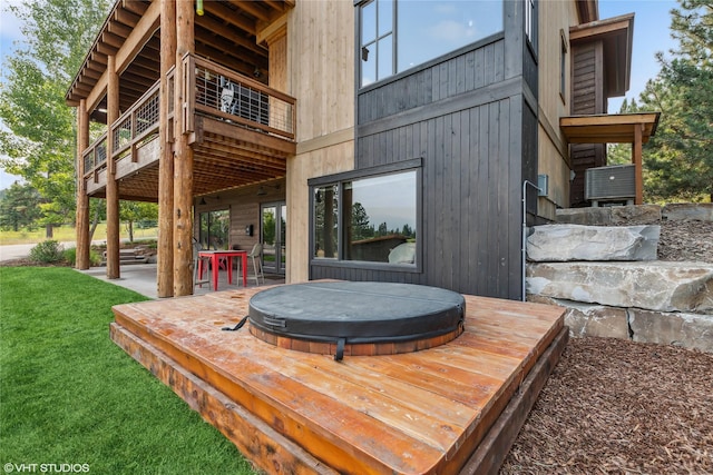 62 Wilderness Lodge Rd, Eureka, MT 59917 - wooden deck with a covered hot tub, a lawn, and a patio area