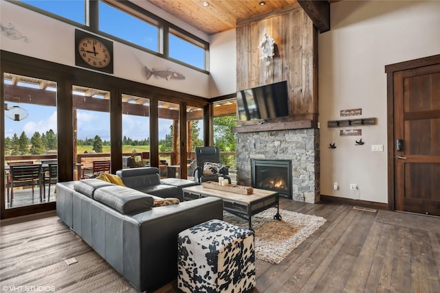 62 Wilderness Lodge Rd, Eureka, MT 59917 - living area with wood ceiling, hardwood / wood-style flooring, a high ceiling, a stone fireplace, and baseboards