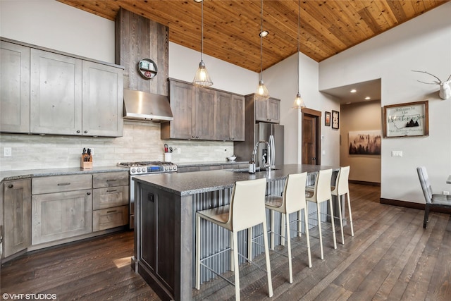 62 Wilderness Lodge Rd, Eureka, MT 59917 - kitchen with tasteful backsplash, a breakfast bar area, wooden ceiling, extractor fan, and appliances with stainless steel finishes
