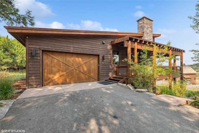 62 Wilderness Lodge Rd, Eureka, MT 59917 - exterior space featuring a chimney, a garage, and driveway