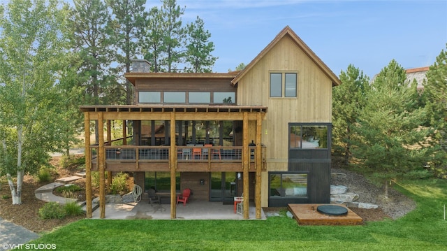 62 Wilderness Lodge Rd, Eureka, MT 59917 - rear view of house with a chimney, a deck, a yard, and a patio area