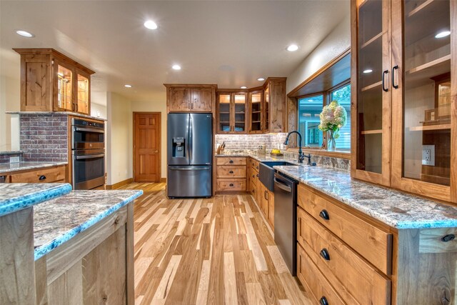 NHN Bears Rd, Stevensville, MT 59870 - kitchen featuring tasteful backsplash, stainless steel appliances, a sink, light wood-style floors, and light stone counters