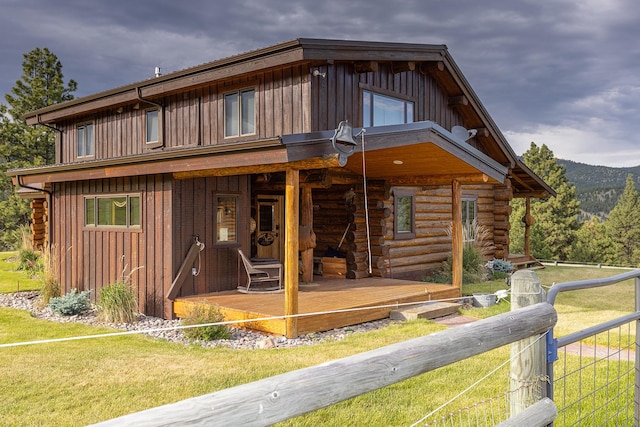 587 Cozy Ln, Helmville, MT 59843 - back of house with board and batten siding, fence, a yard, and log exterior