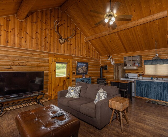 587 Cozy Ln, Helmville, MT 59843 - living room with high vaulted ceiling, wood finished floors, a ceiling fan, beam ceiling, and a wood stove