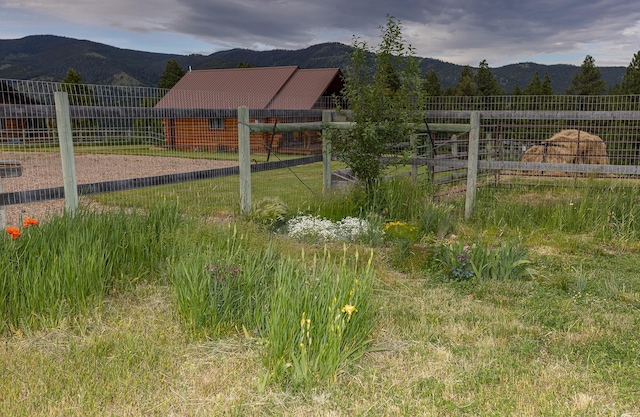 587 Cozy Ln, Helmville, MT 59843 - view of yard featuring an outbuilding, a mountain view, and fence