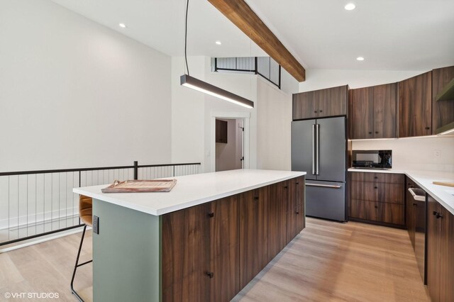 34 Grizzly Ct, Bigfork, MT 59911 - kitchen featuring stainless steel appliances, light wood-style floors, a kitchen island, modern cabinets, and light countertops