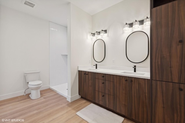 34 Grizzly Ct, Bigfork, MT 59911 - bathroom featuring toilet, wood finished floors, baseboards, and double vanity