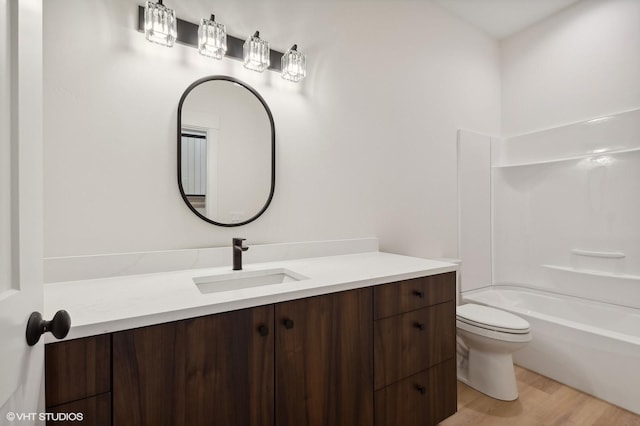 34 Grizzly Ct, Bigfork, MT 59911 - full bathroom with vanity, wood finished floors, toilet, and bathtub / shower combination