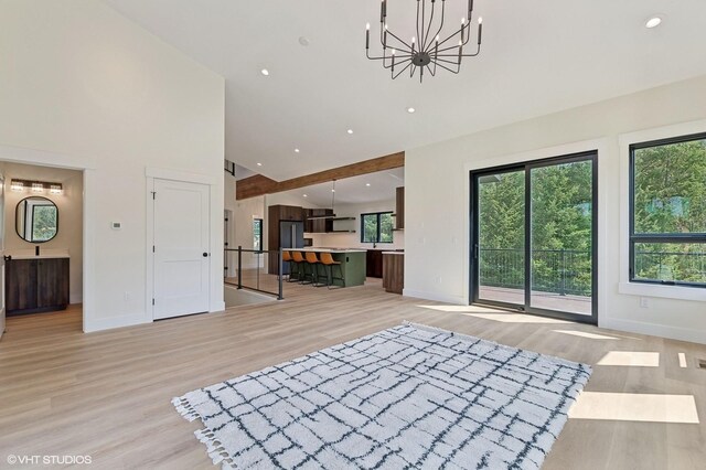 34 Grizzly Ct, Bigfork, MT 59911 - unfurnished living room featuring high vaulted ceiling, a chandelier, light wood finished floors, and recessed lighting