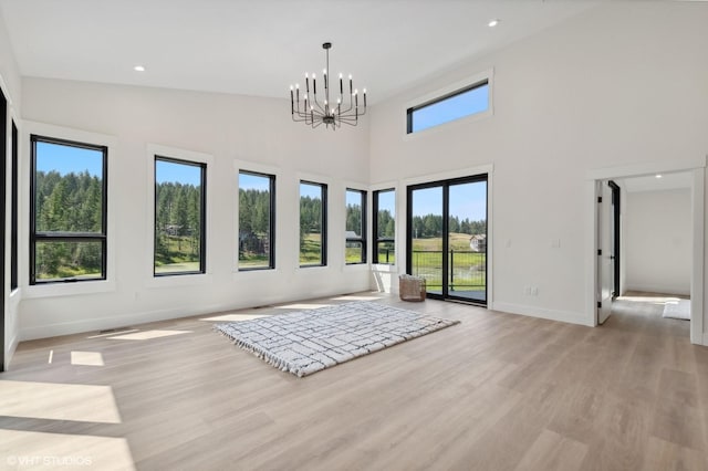34 Grizzly Ct, Bigfork, MT 59911 - unfurnished living room with light wood finished floors, baseboards, a chandelier, and recessed lighting