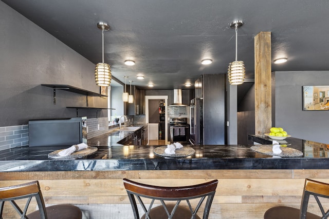 4528 Adellon Ct, Stevensville, MT 59870 - kitchen featuring wall chimney exhaust hood, freestanding refrigerator, backsplash, and decorative light fixtures