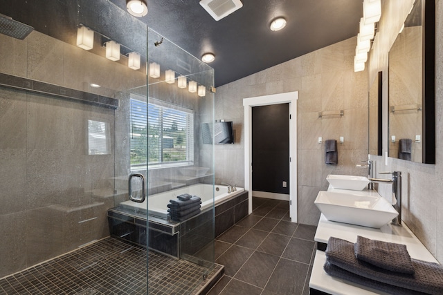 4528 Adellon Ct, Stevensville, MT 59870 - full bathroom featuring tile patterned flooring, tile walls, lofted ceiling, a stall shower, and a bath