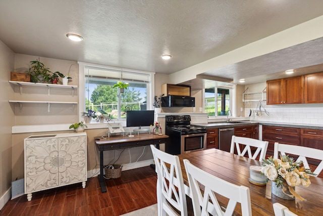 4528 Adellon Ct, Stevensville, MT 59870 - kitchen featuring stainless steel appliances, dark wood-style floors, healthy amount of natural light, brown cabinetry, and a textured ceiling