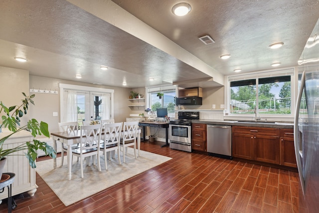 4528 Adellon Ct, Stevensville, MT 59870 - kitchen featuring stainless steel appliances, dark wood-style flooring, plenty of natural light, dark countertops, and a textured ceiling
