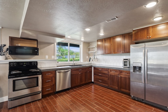 4528 Adellon Ct, Stevensville, MT 59870 - kitchen featuring appliances with stainless steel finishes, a textured ceiling, dark wood-style flooring, dark countertops, and recessed lighting