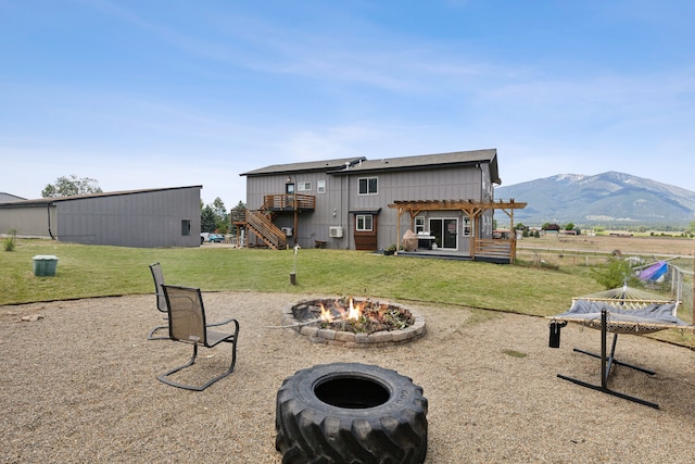4528 Adellon Ct, Stevensville, MT 59870 - back of property featuring a fire pit, a pergola, a lawn, stairs, and a deck with mountain view