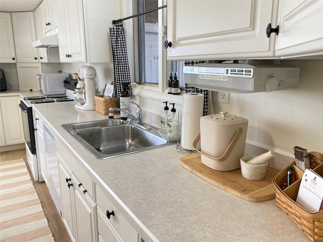 kitchen with light countertops, a sink, white cabinetry, range with electric stovetop, and under cabinet range hood