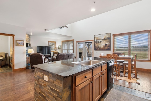 6205 Davos Ln Unit B, Whitefish, MT 59937 - kitchen with black dishwasher, dark wood-style floors, an island with sink, dark stone counters, and recessed lighting