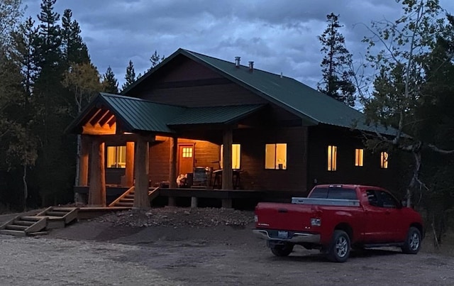 back of property with covered porch and metal roof