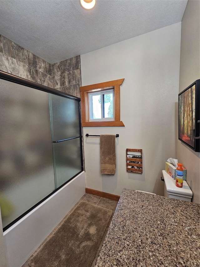 full bath with enclosed tub / shower combo, baseboards, and a textured ceiling